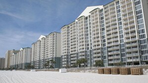 A beachfront hotel with multiple high-rise buildings, balconies, and a sandy beach area. - Tower 3-102 Long Beach Resort. Free Beach Chair Service! (Panama City Beach)