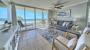 A spacious living room with a balcony overlooking the ocean, a gray sofa, a coffee table, and a ceiling fan. - Tower 3-102 Long Beach Resort. Free Beach Chair Service! (Panama City Beach)