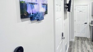 A hallway with a waterfall painting, a thermostat, and a door labeled "Business 14".