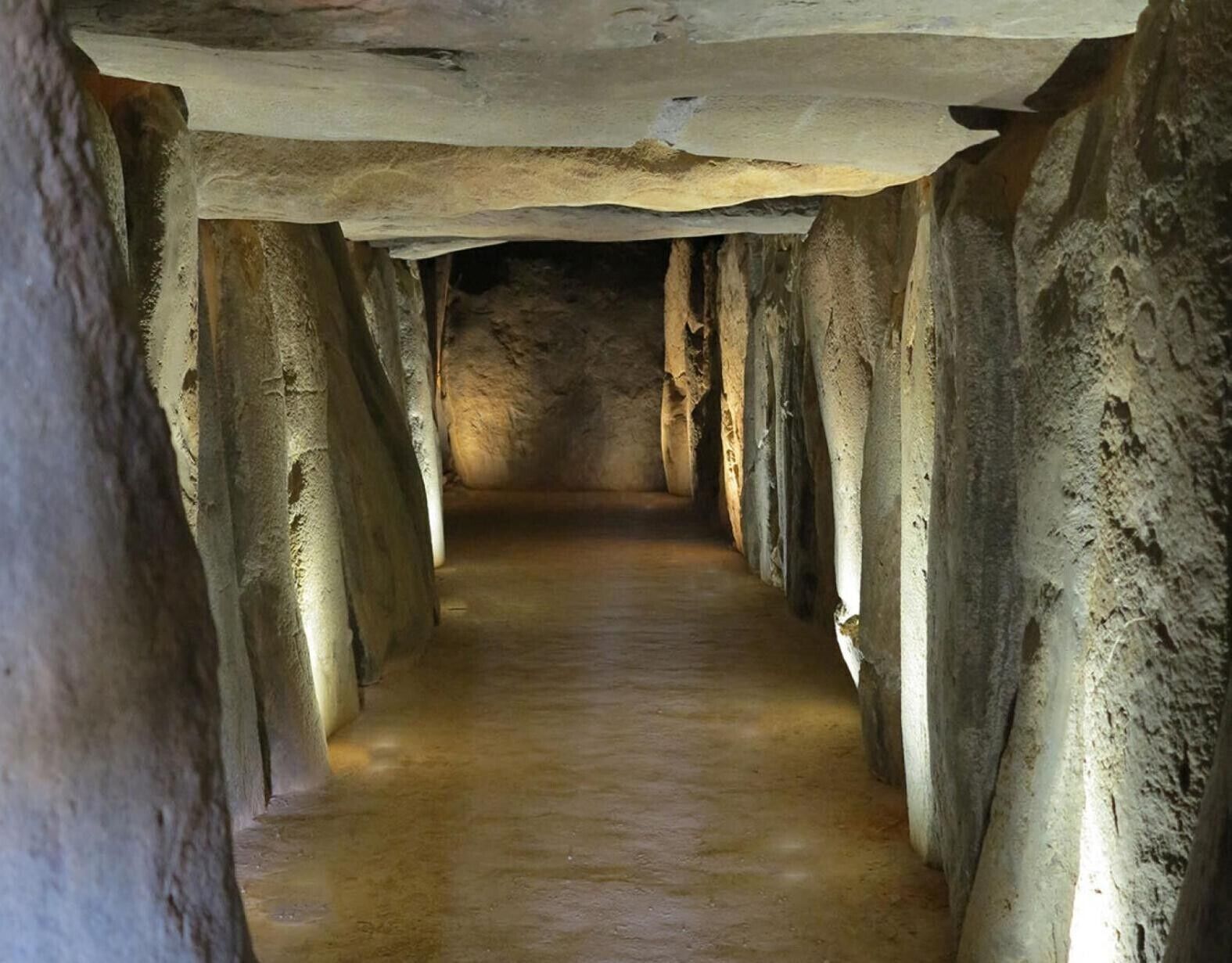 Un estrecho pasaje con techos altos y paredes de piedra.