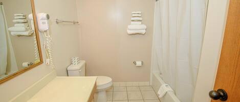 A bathroom with a sink, toilet, and shower.