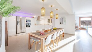 A modern kitchen with white cabinets, a wooden dining table, and pendant lights. - Holiday Home 'Mimar Altea Remedi' with Sea View, Wi-Fi and Air Conditioning (Altea)