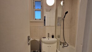 A compact bathroom with a toilet, sink, and bathtub.