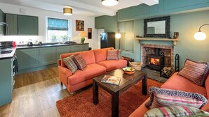A modern living room with a sofa, coffee table, and fireplace. - Ddwylig Isaf Farmhouse - UK48624 (Rhyl and Prestatyn)