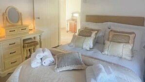 A hotel room with a bed, two bedside tables, a dresser, and a mirror. - Ddwylig Isaf Farmhouse - UK48624 (Rhyl and Prestatyn)