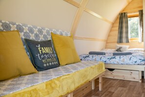 Een knus interieur met een houten bank en een bed met beddengoed met een patroon.
