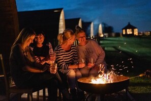 Four people sitting around a campfire at night. - Ensuite Wooden Cabin in Rural Staffordshire (Tamworth)