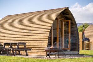 A wooden cabin with a sloped roof, a fire pit, and a picnic table. - Ensuite Wooden Cabin in Rural Staffordshire (Tamworth)