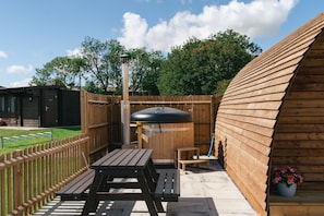 A wooden deck with a barbecue grill, picnic table, and seating area. - Ensuite Wooden Cabin With Hot Tub (Tamworth)