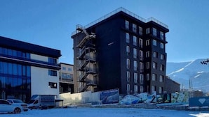 Een meerlaags gebouw met een moderne architectuur, met een opvallende trap en meerdere ramen.