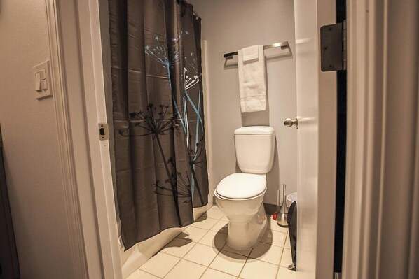 Un baño pequeño con inodoro, toallero y cortina de ducha.