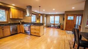 Una cocina amplia con armarios de madera, una isla central y un comedor con mesa y sillas.