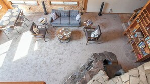 A spacious living area with a stone fireplace, a grey sofa, and a wooden coffee table.
