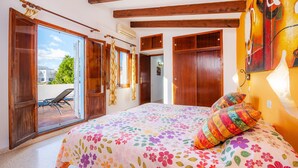 A bedroom with a bed, a window, and a door.