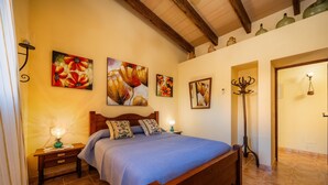 Un dormitorio con cama de madera, mesita de noche, lámpara y decoración en la pared.
