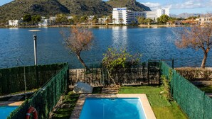Un hôtel doté d’une piscine, entouré d’une clôture, et offrant une vue sur un lac et des montagnes.