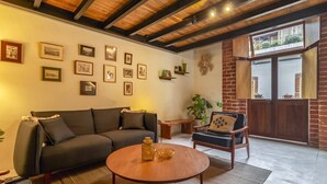 A living room with a sofa, a coffee table, a chair, and a window with a view. - Departamento Emilio Dondé zona céntrica CDMX (Ciudad de México)