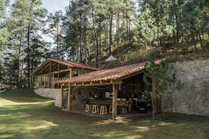 Una cabaña rústica con fachada de madera, un porche cubierto y una pared de piedra.