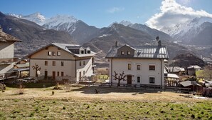 A mountain village with traditional buildings, a clear sky, and snow-capped mountains in the background. - Apartment 'A5' with Mountain View, Private Terrace and Wi-Fi (Saint Pierre)