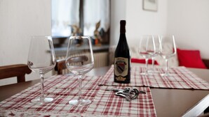 A dining table with wine glasses, a wine bottle, and a corkscrew. - Apartment 'A5' with Mountain View, Private Terrace and Wi-Fi (Saint Pierre)