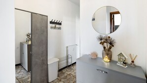A modern bathroom with a grey cabinet, a round mirror, a 'welcome' sign, a radiator, and a small decorative house on the counter. - Apartment 'Vista Mare A 150 Mt Dalla Spiaggia' with Sea View, Private Terrace and Air Conditioning (Pietra Ligure)