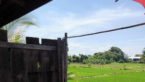 A large outdoor water feature with a wooden structure and a view of green fields. - hueankwankhao  (Chom Thong)