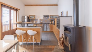 Una cocina moderna con una isla central, taburetes de bar, una estufa y vistas al exterior.