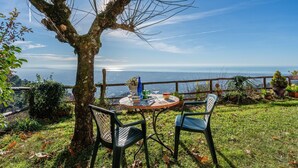 Ein Tisch mit Stühlen vor der Tür, mit Blick auf ein Gewässer.