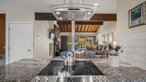 A modern kitchen with a built-in stove, a coffee maker, and a kettle on the countertop. - Cozy Condo Near the VIllage (Sunriver)