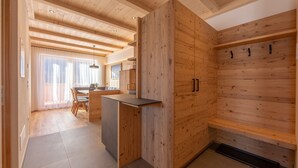 Una cocina moderna con armarios de madera, un comedor con mesa y sillas, y un banco empotrado.