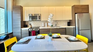 A modern kitchen with a central island, stainless steel appliances, and yellow chairs. - 2 BR | 2 BT | Downtown | Free Valet Parking | # 6 (Dallas)