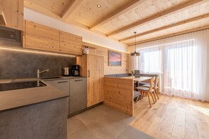 Una cocina moderna con armarios de madera, una isla integrada y un comedor con vistas al exterior.