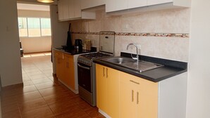 Una cocina con estufa a gas, horno, lavaplatos y armarios.