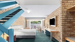 A modern hotel room with a bed, a desk, a TV, and a staircase. - Motel Flinders (Flinders)