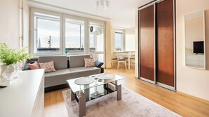 Una sala de estar moderna con un sofá, una mesa de centro de vidrio y un armario con puerta corredera.
