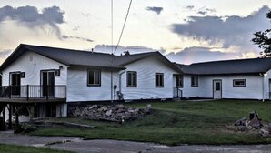 Una hilera de casas móviles blancas con un patio césped y cielo nublado.