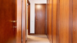 Un pasillo con puertas de madera y piso de color claro.
