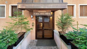 Entrada de un edificio con un cartel que dice 'CONDOMINIO CASA DEGLI ORSI' y el número '19' en la pared.