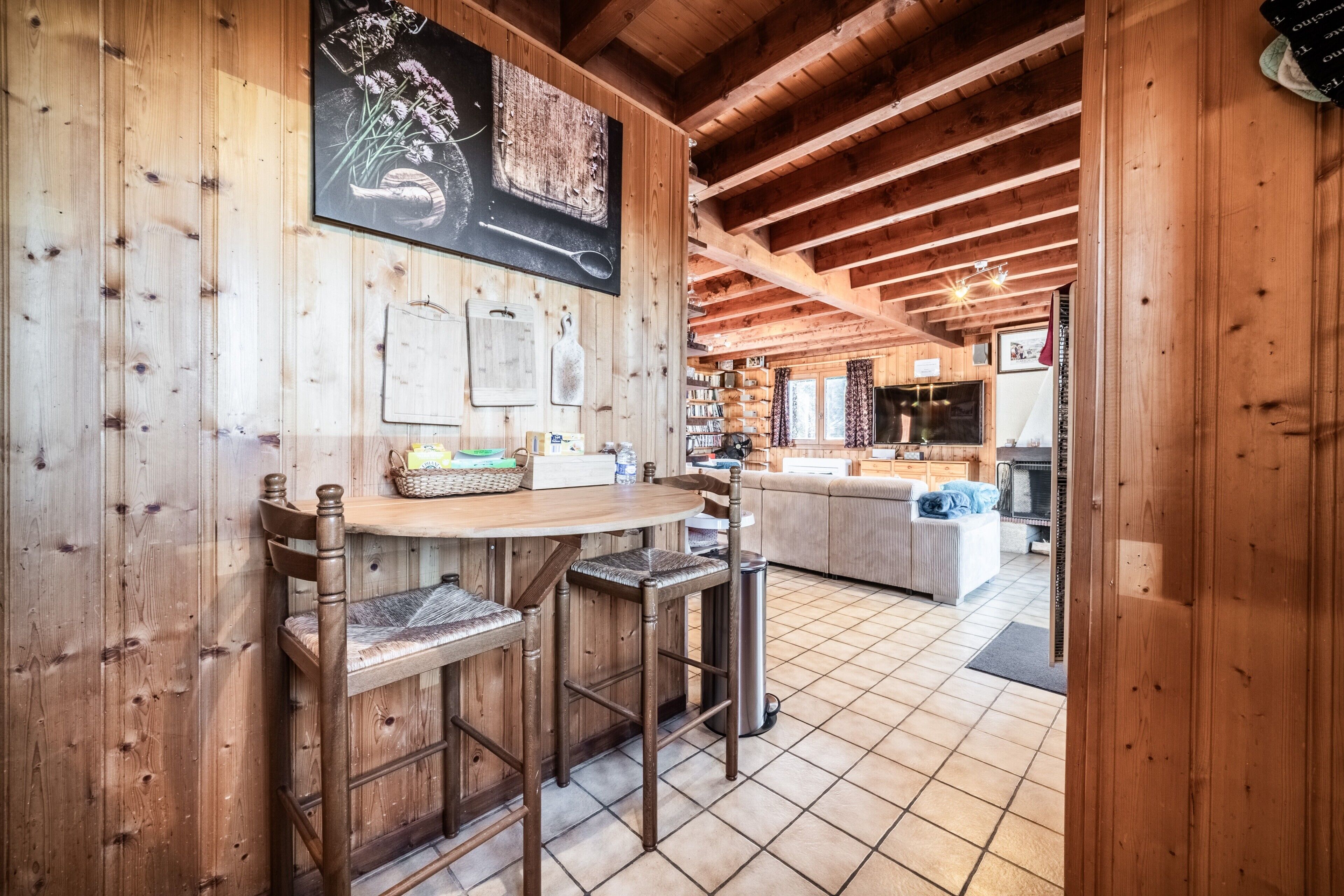 Un intérieur en bois comprenant un coin cuisine, des tabourets de bar et une table à manger.