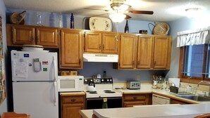 A kitchen with wooden cabinets, a refrigerator, a microwave, a stove, and a sink. - Cozy 3-bedroom/3-bathroom Townhouse, minutes from Loon Mt with an indoor pool (North Woodstock)
