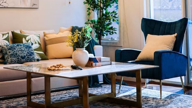 A modern living room with a sofa, a chair, a coffee table, and a hanging light fixture. - StayAU Pakenham Townhouse with Lakeview (Pakenham)