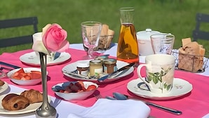 A picnic setup with food, drinks, and a rose centerpiece on a table outdoors. - ‘Marquise De Pompadour’ Guest Room with Pool, Breakfast, Shared Garden & Wi-Fi (Suzay)