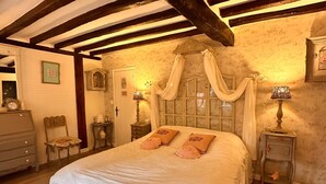 A bedroom with a large bed, wooden beams, a chandelier, and a small table with a lamp. - ‘Marquise De Pompadour’ Guest Room with Pool, Breakfast, Shared Garden & Wi-Fi (Suzay)