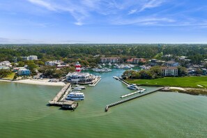 A marina with boats docked, a lighthouse, and buildings in the background. - RBC Heritage Views From Your Deck, 4BR Villa Steps to Harbour Town (Hilton Head Island)