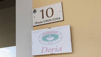 Un mur avec deux panneaux : l’un indiquant le numéro 10 et l’autre portant l’inscription « Bed & Breakfast Doria ».