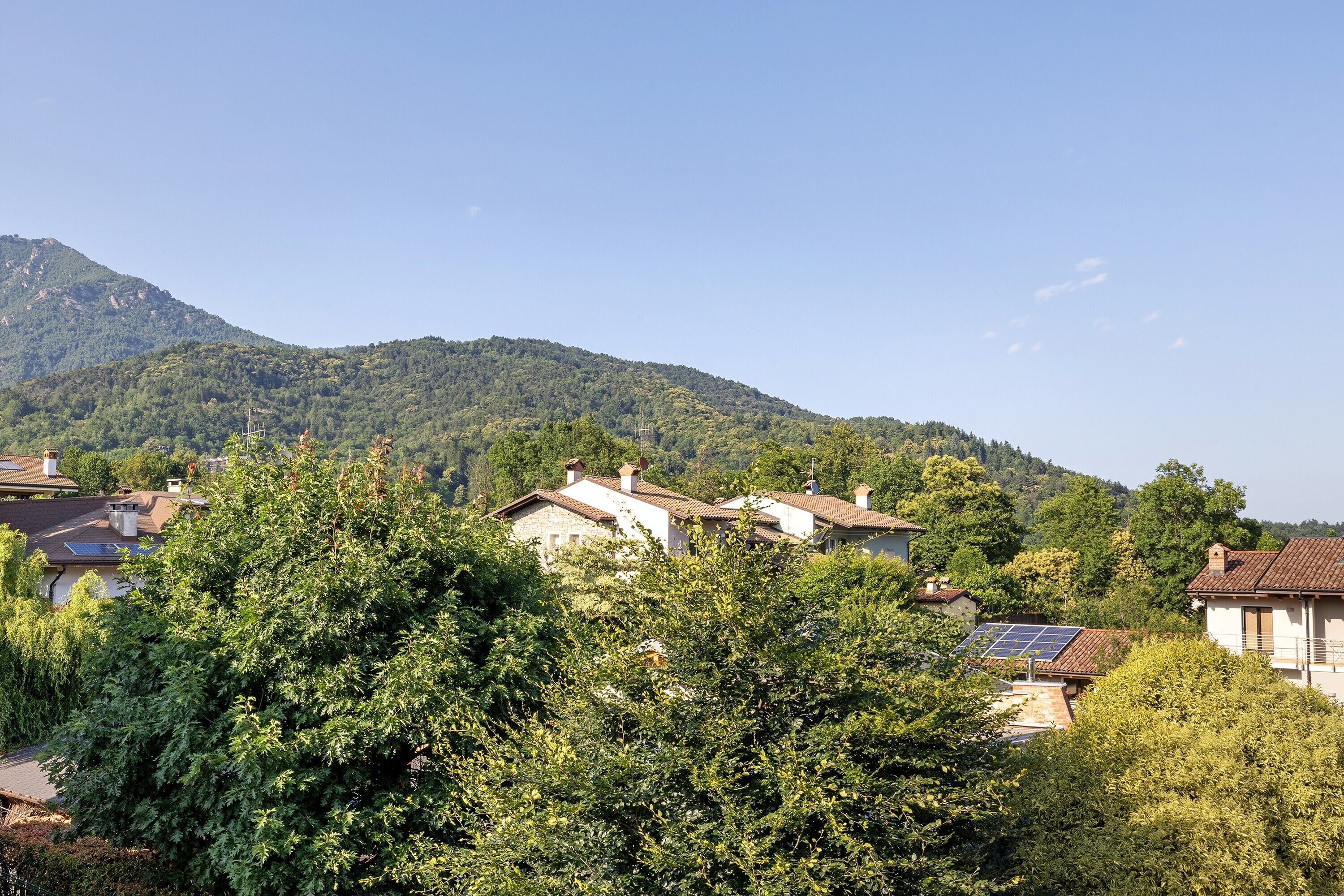Zona residencial con casas, árboles y una montaña al fondo.