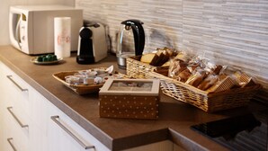 A kitchen counter with a toaster, kettle, and various food items.