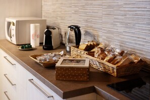A kitchen counter with a toaster, kettle, and various food items.