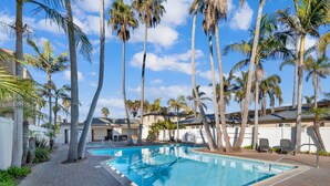 A swimming pool surrounded by palm trees and a brick pathway. - Oceanfront Oasis with Stunning Panoramic Views in Pacific Beach! - Sea It All (San Diego)