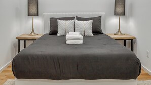 Een moderne slaapkamer met een groot bed, twee nachtkastjes en twee lampen.